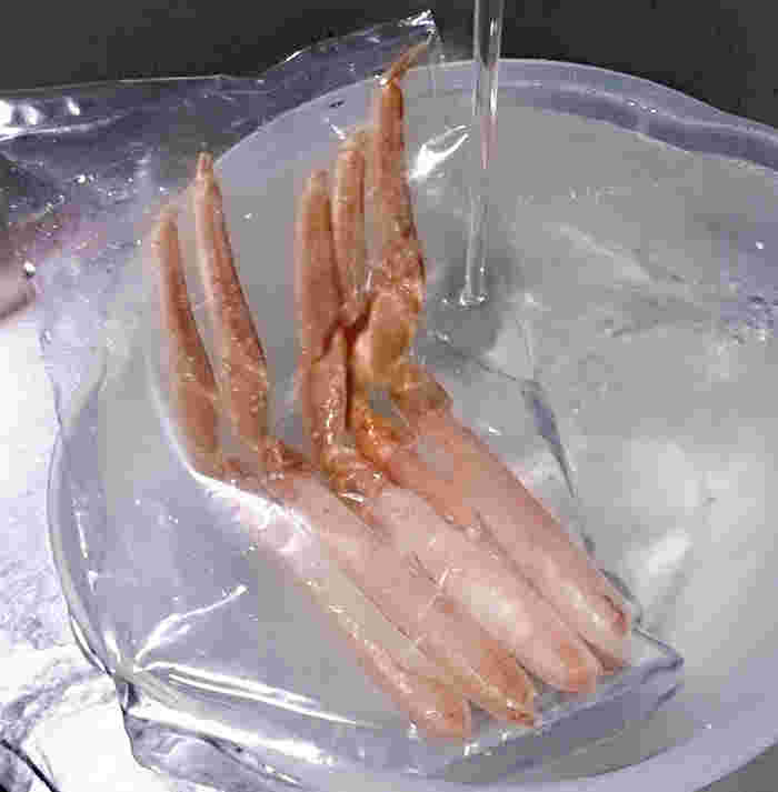 冷凍カニを水の張ったボウルに入れて流水解凍する様子