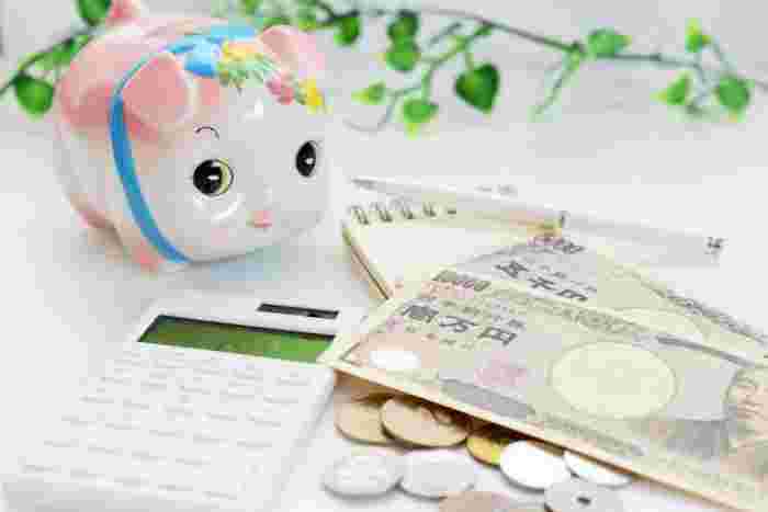 貯金箱と電卓とお金が並べられている