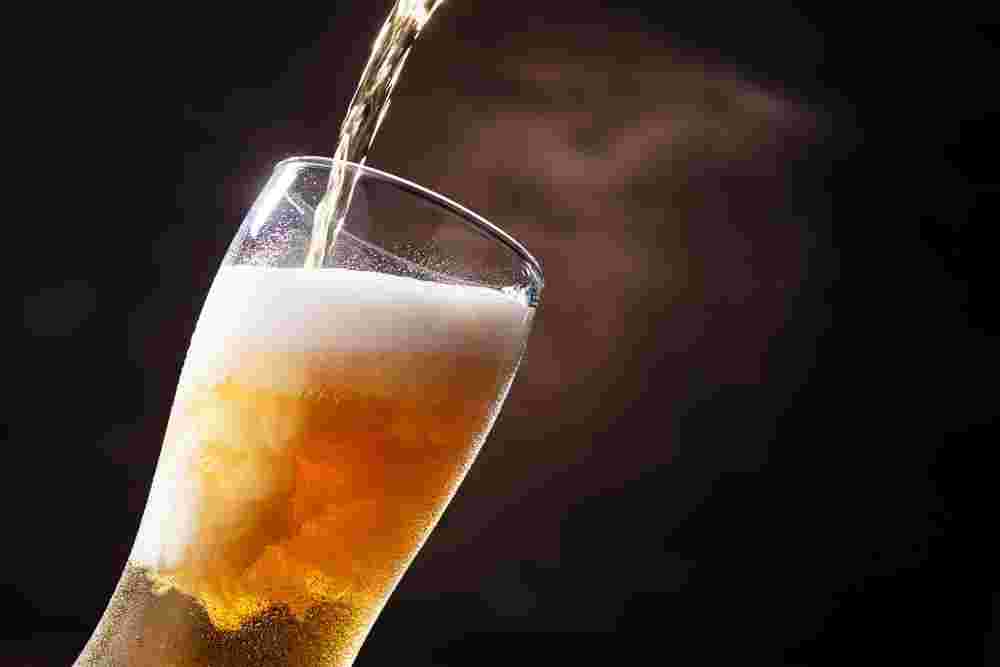 グラスにビールを注いでいる様子