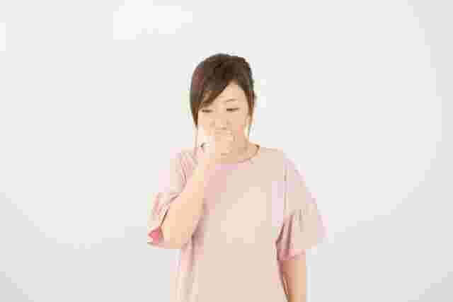 口に手を当てる人