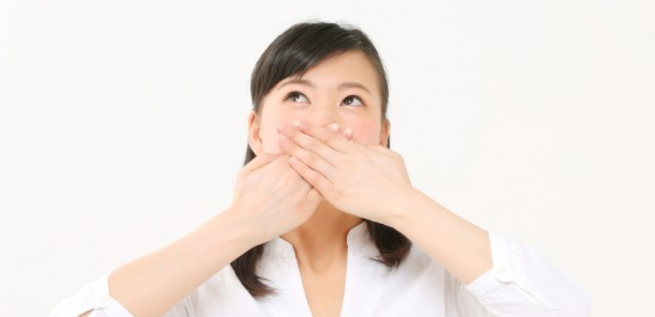 口を抑えている女性