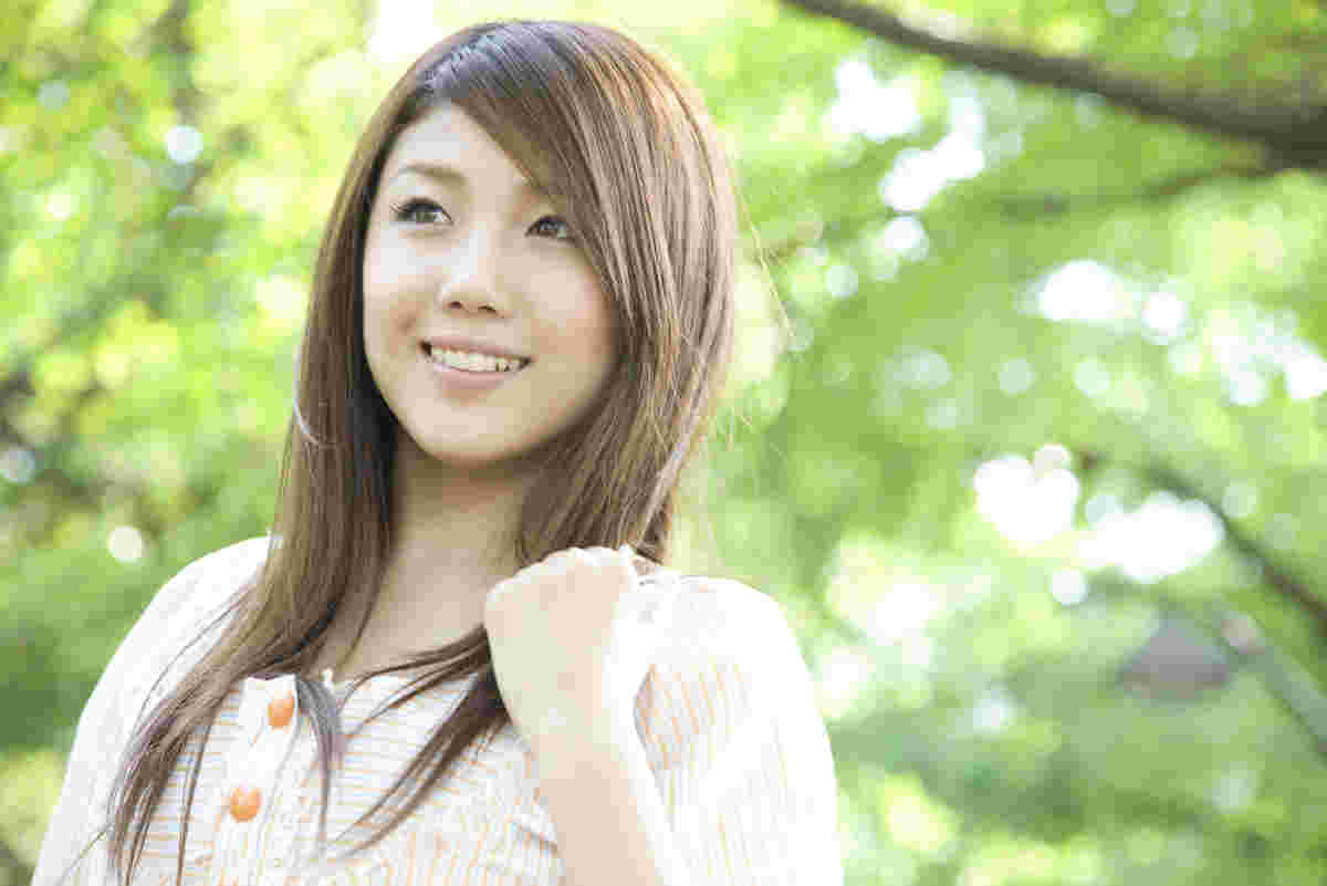 新緑の中を元気に歩く女性