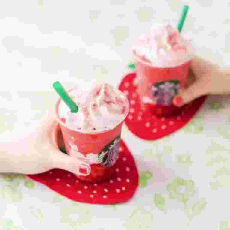 手に持ったストロベリーベリーマッチフラペチーノレッド