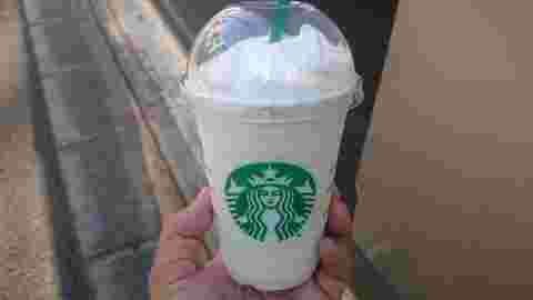 左手で持ったバニラクリームフラペチーノ