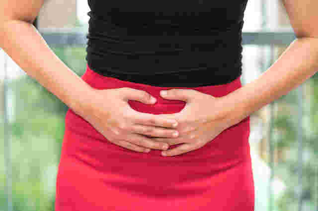お腹に手を当てる女性