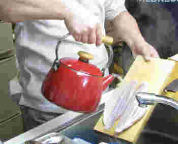 魚に熱湯をかけている