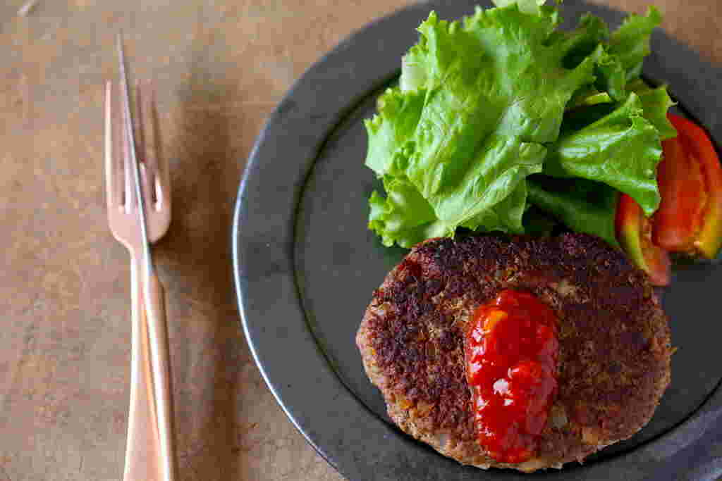 ケチャップをかけたレバーハンバーグとフォーク