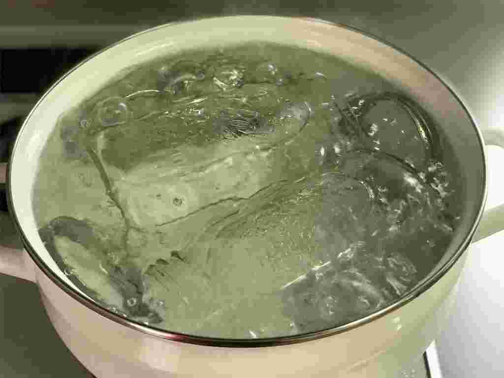 白い大きな鍋に数個の瓶を煮詰める