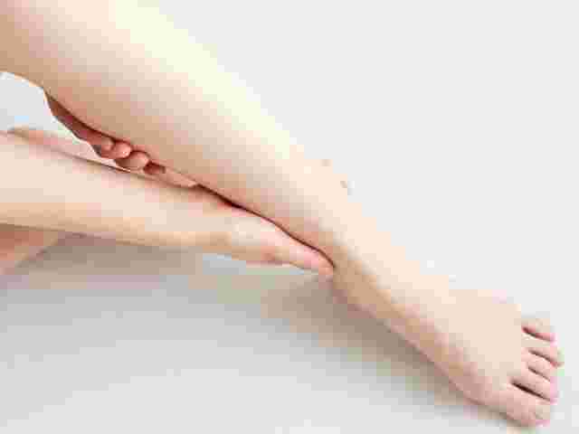むくんだ足をマッサージしている女性