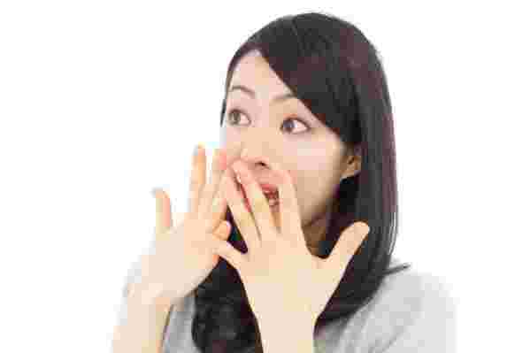 驚きのあまり両手を口に当てるしぐさの女性