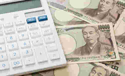 白い電卓と一万円札がたくさん