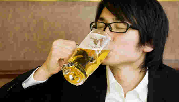 ビールジョッキで一気飲みする男性