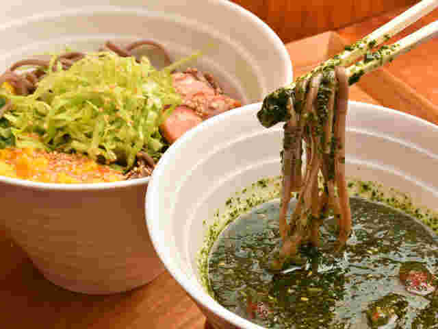 そばうさのバジル冷そばで、バジルのつけ麺に麺を落とし入れる