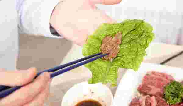 焼き肉をサンチュで包む様子