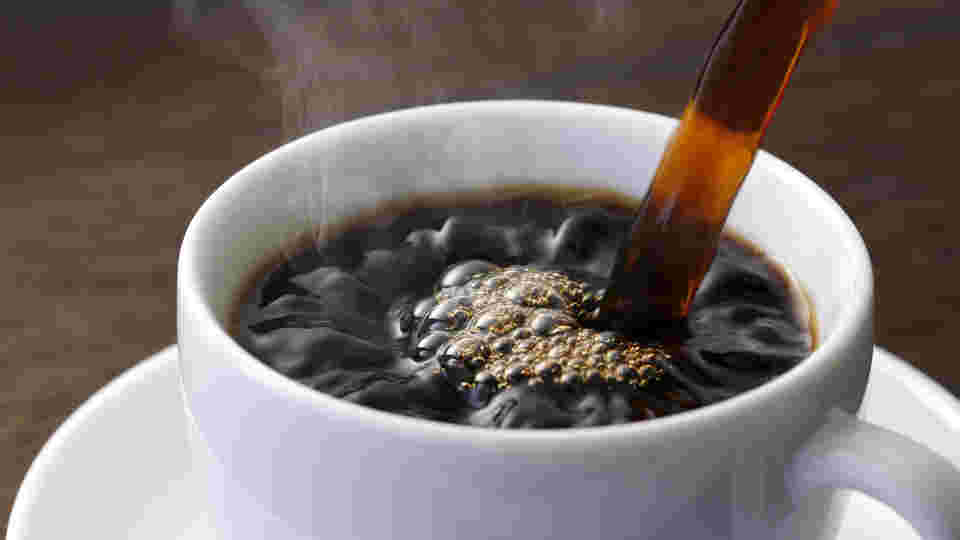 白いカップにコーヒーを注いでいるところ