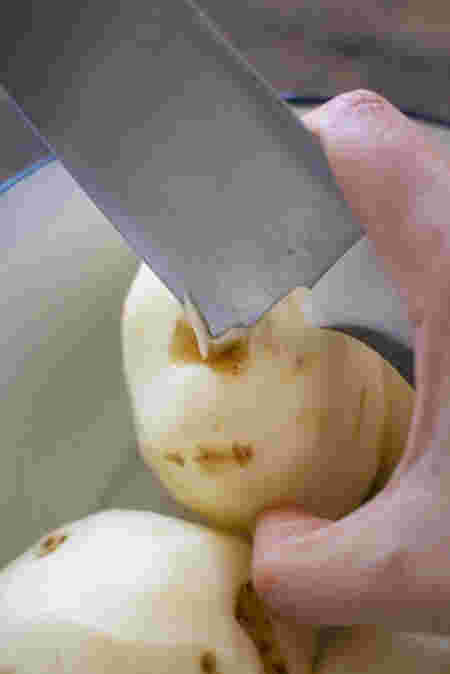 包丁でじゃがいもの芽を取り除く様子