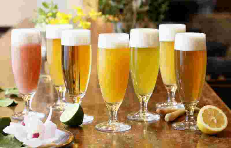 さまざまな種類のビールカクテルの入ったグラスをテーブルに並べる