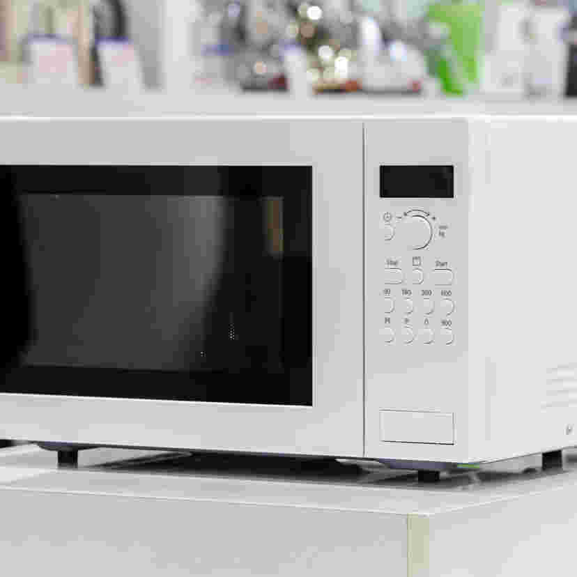 白棚の上に置いてある白い電子レンジ