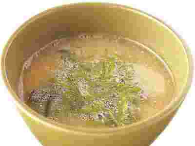 茶系のお茶碗にめかぶ入りの味噌汁を注いだ様子