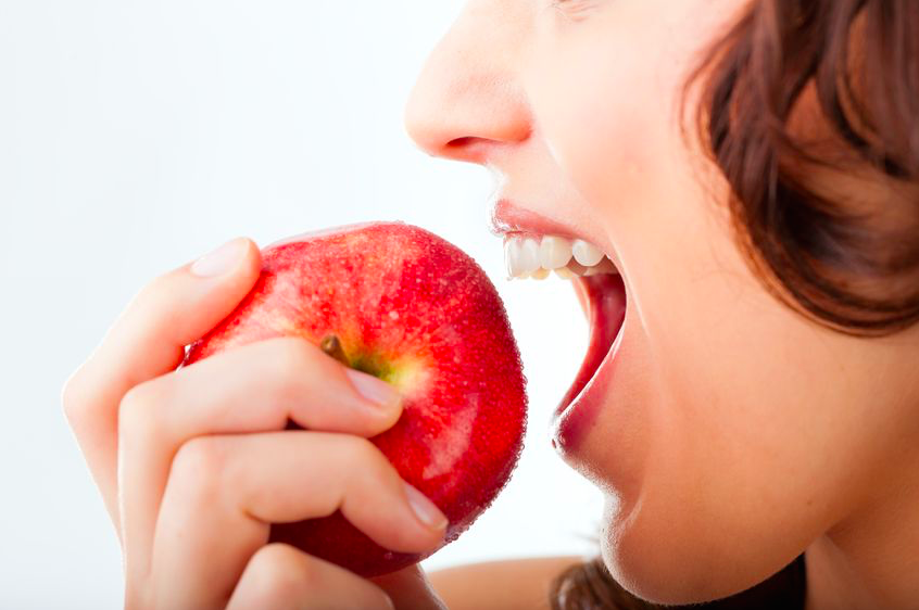 丸ごと1個のりんごを食べようとする女性