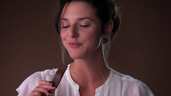 チョコレートをうっとりした表情で食べる女性