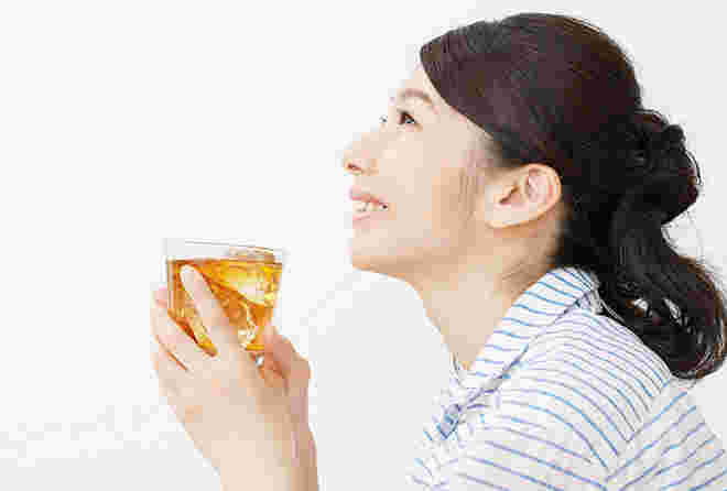 ウーロン茶を飲む笑顔の女性
