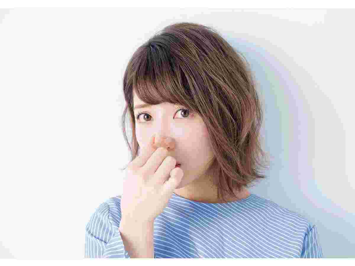 口臭が臭くて鼻をつまむ女性