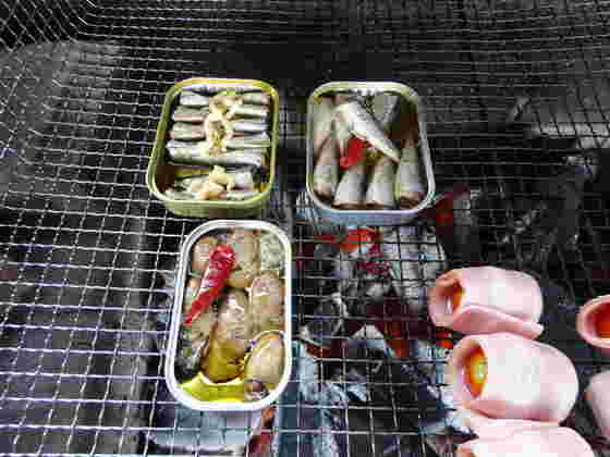 BBQの網の上のオイルサーディン缶とその他