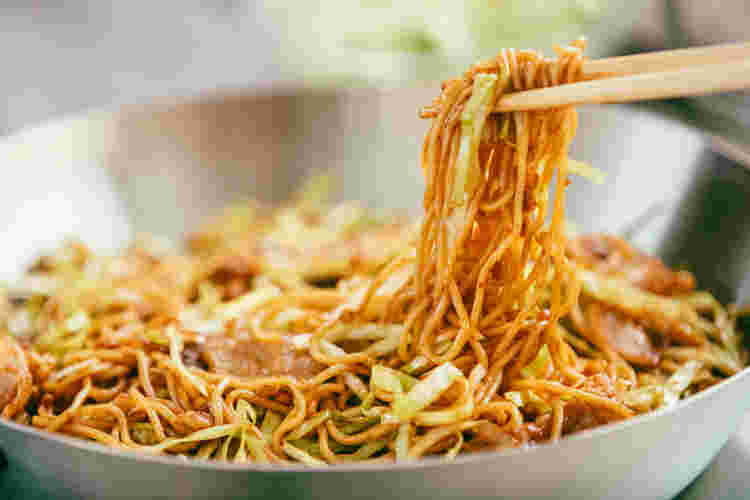フライパンで焼きそばを炒めている
