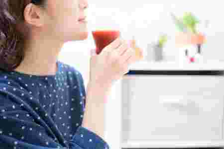 トマトジュースを飲む女性
