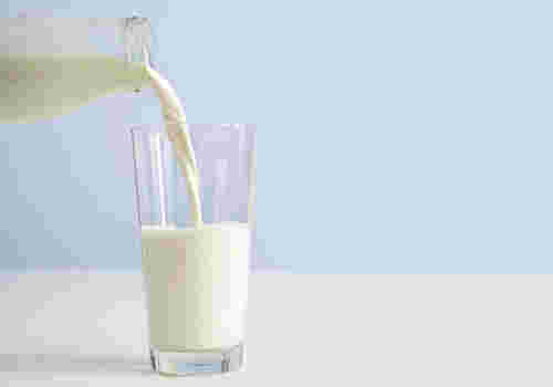 牛乳をグラスに注ぐ