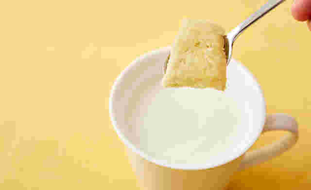 冷凍生姜を一欠片、スプーンに乗せてミルクに入れようとしている画像