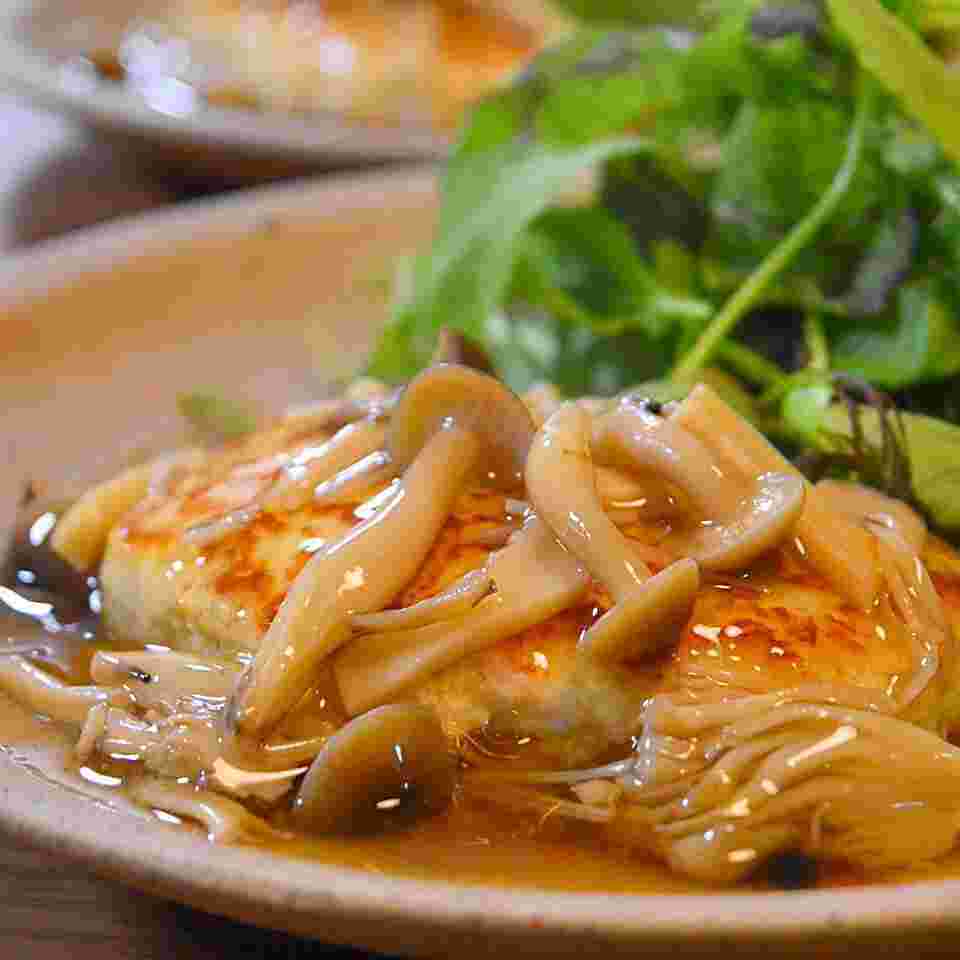 緑の野菜と手前にあんかけがたっぷりかかったハンバーグ