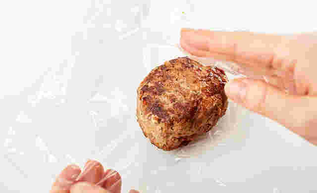 ハンバーグをラップで包もうとしている