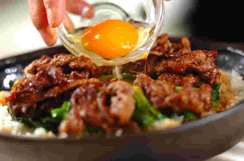ビビンバ風焼肉丼に卵黄を乗せているイメージ