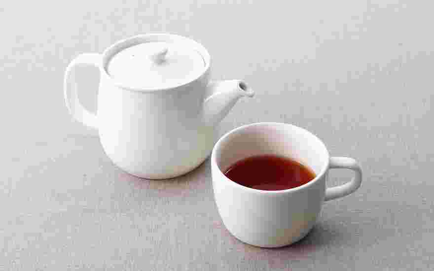 白いポットと白いマグカップに入った紅茶