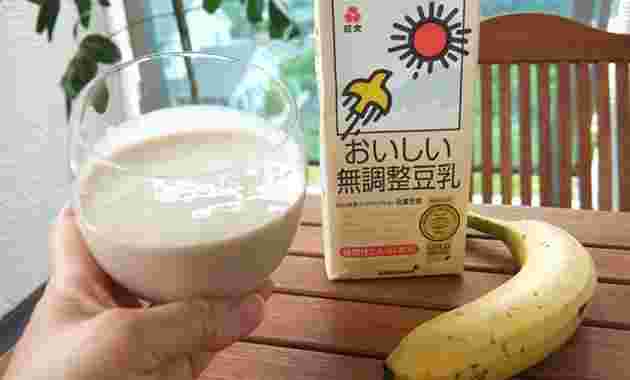 豆乳のパックとグラスに入った豆乳とバナナ