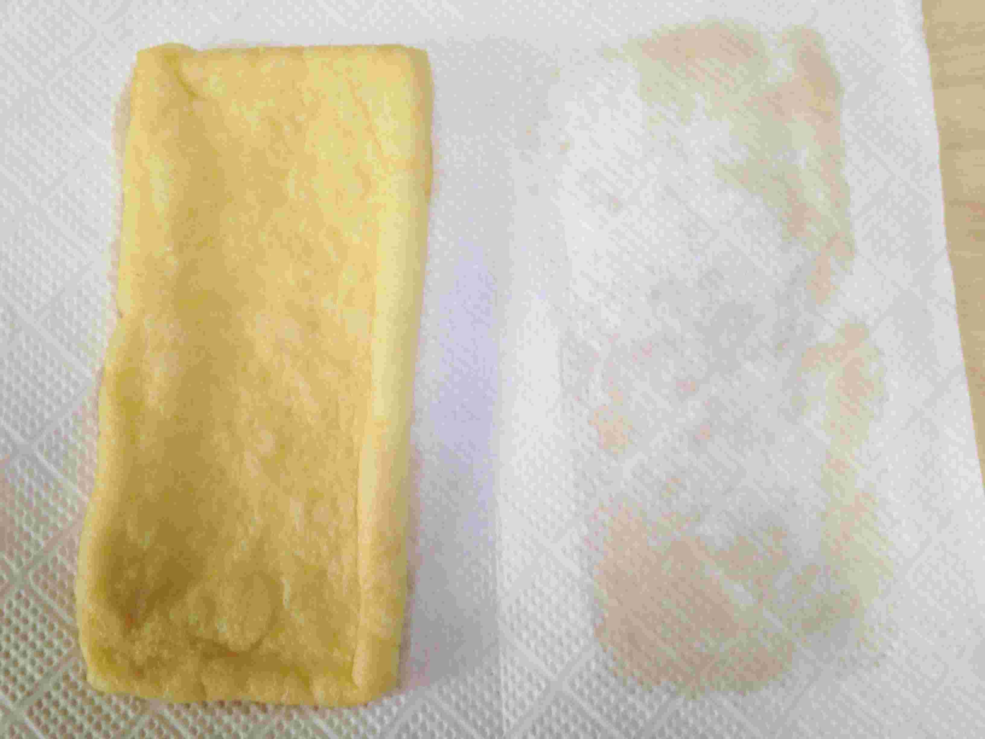 キッチンペーパーを使って油揚げを挟んでいる