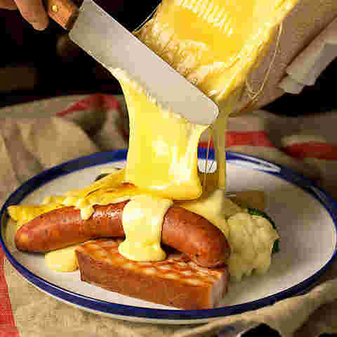 とけたチーズを食材にかけているところ