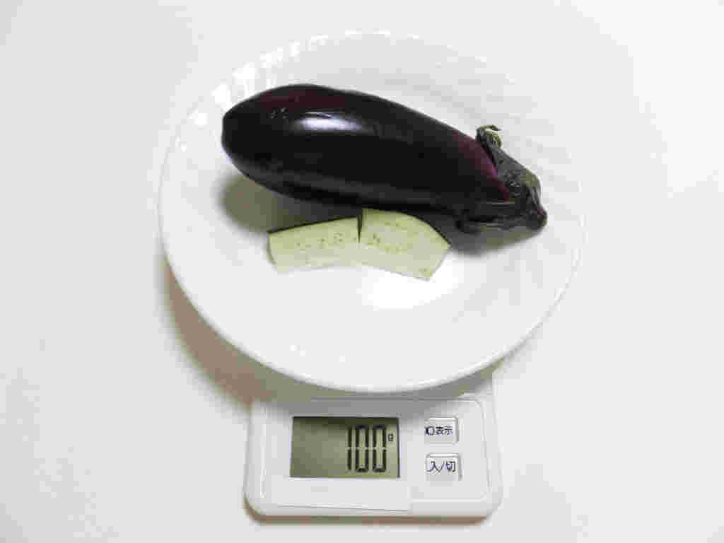 皿に乗ったなすがカロリーやgを計る機械の上に乗っている
