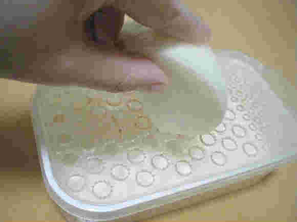 白いおろし器で玉ねぎをすりおろしている様子