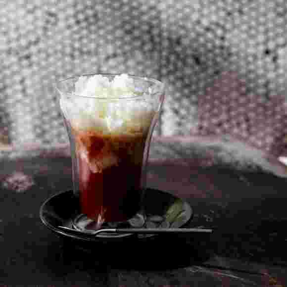 凍らせた飲むヨーグルトをトッピングしたドリンクとスプーン