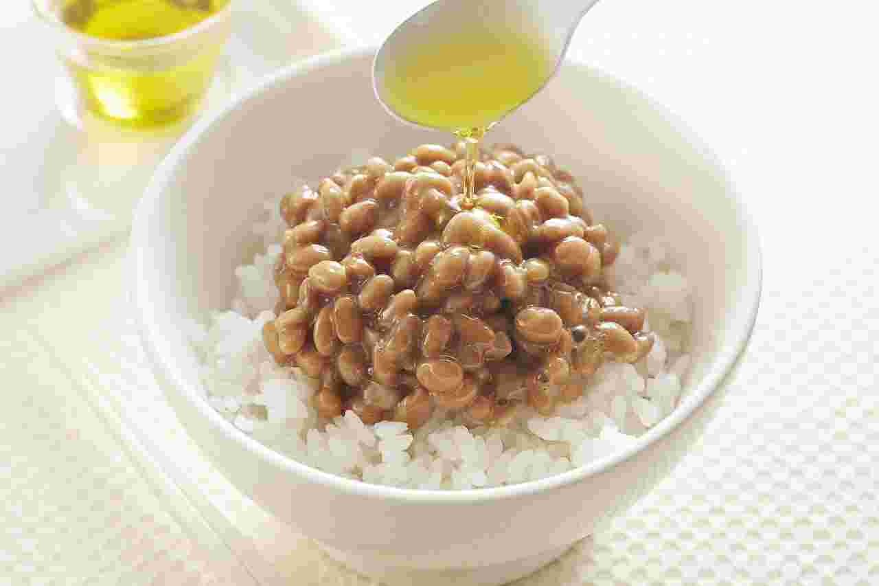 納豆の上にオリーブオイルをかけている様子