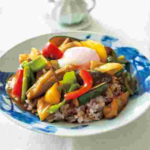 青い柄の入った器に夏野菜がたっぷりのったカレー