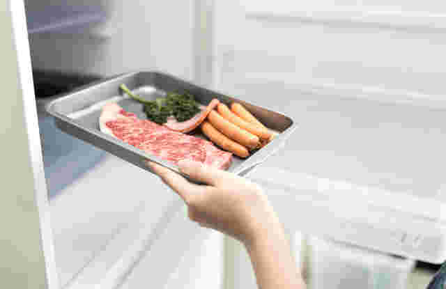 ウインナーや肉がのったトレイを冷蔵庫に移動して解凍させるところ