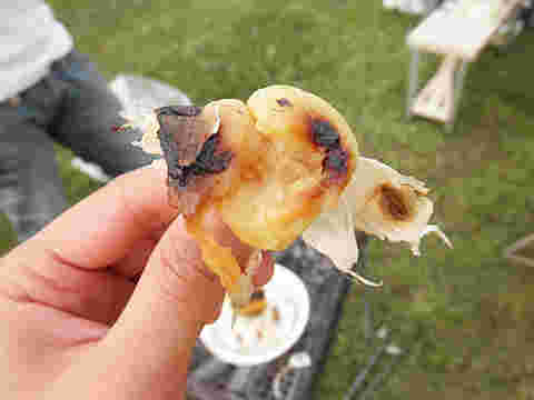 焼きにんにくを食べようと手に持っている人