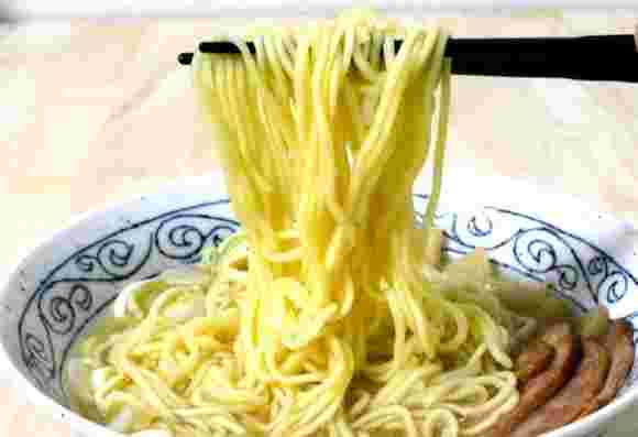 インスタントラーメンを箸で持ち上げている画像