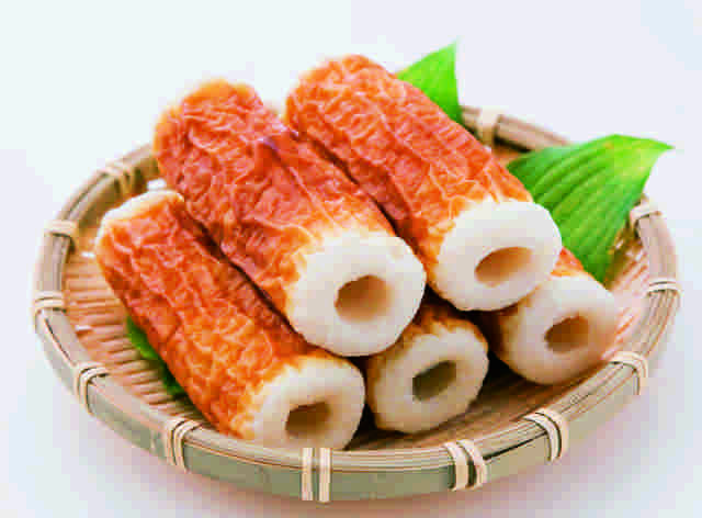ざるに緑の葉が敷かれて焼きちくわが5本のっている