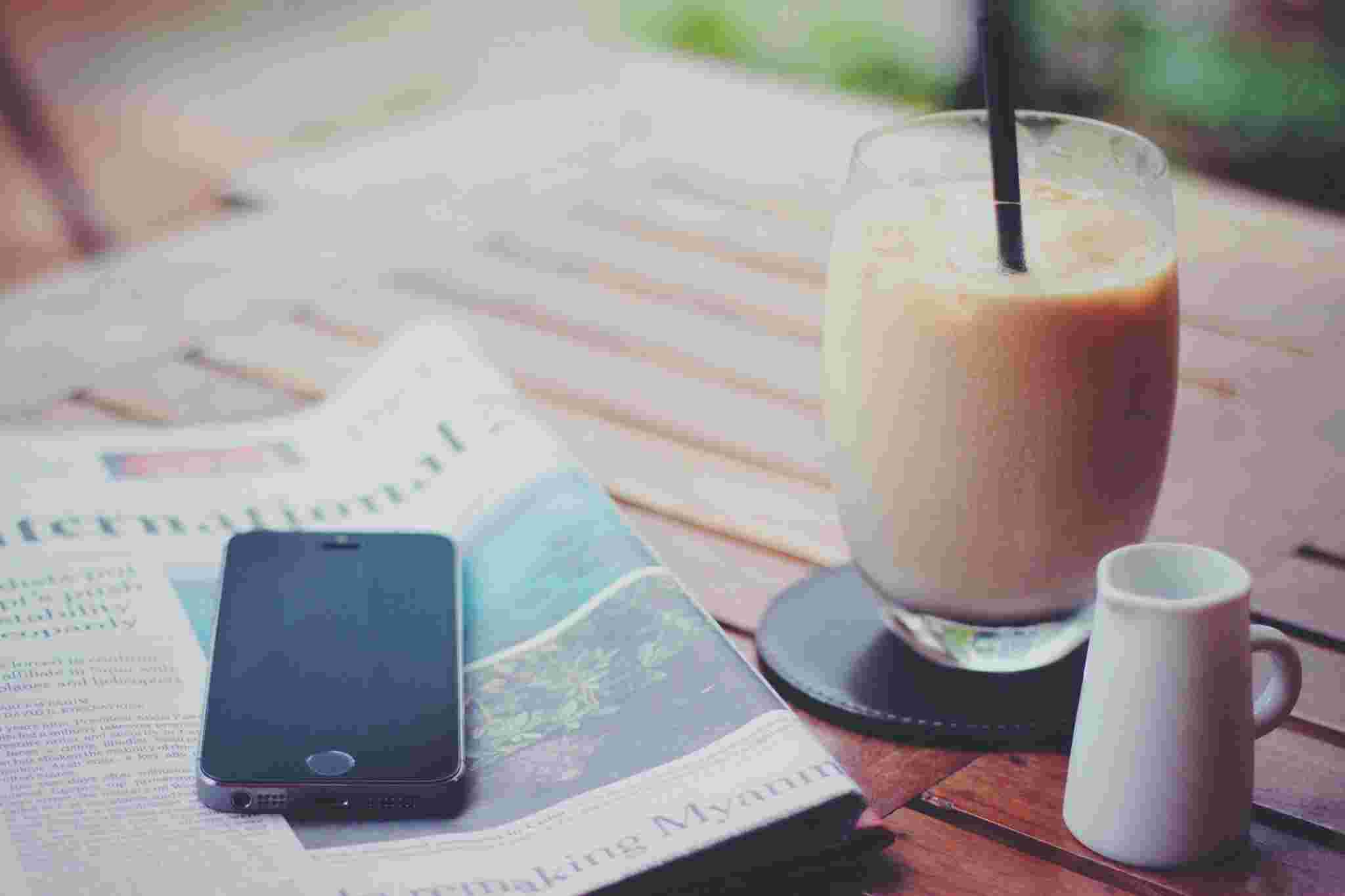 スマホと新聞とアイスコーヒー