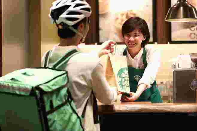 スタバの店員から商品を受け取るUberEats配達員
